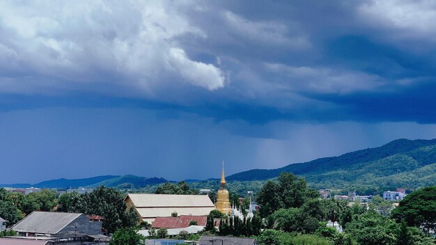 Zdjęcie panoramiczny widok budynków i gór na chmurnym niebie