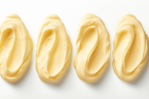 Panoramiczny widok na cztery teksturowane loki masła na białym tle