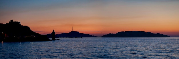 Panoramiczny widok na dzielnicę Le Pharo w Marsylii o zachodzie słońca z latarnią morską i za małym archipelagiem zwanym Les Iles Wyspy w języku angielskim