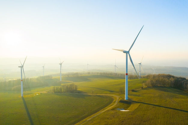 Panoramiczny widok na farmę wiatrową lub park wiatrowy z wysokimi turbinami wiatrowymi do wytwarzania energii elektrycznej