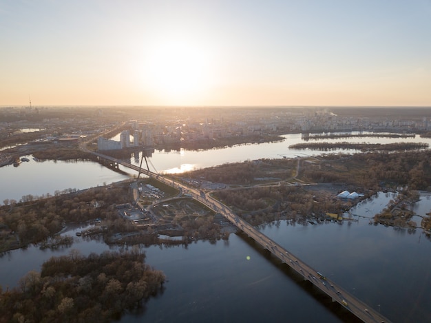 Panoramiczny Widok Na Kijów I Most Północny Z Przejeżdżającymi Samochodami Przez Rzekę Dniepr. Zdjęcie Z Drona