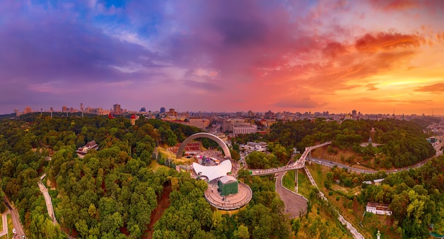 Panoramiczny widok na Kijów z nieba. Zachód słońca nad latem Kijów z Łukiem Przyjaźni Narodów. Nakręcony na dronie. Widok z lotu ptaka