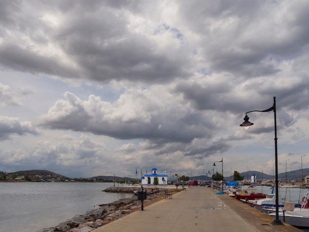 Panoramiczny widok na nabrzeże na wyspie Evia w Grecji z łódką z kościołem w stylu Cycladicstyle