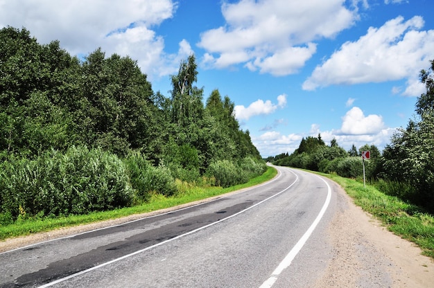 Panoramiczny widok na opustoszałą drogę. Ruszaj w drogę. Piękne chmury na niebie.