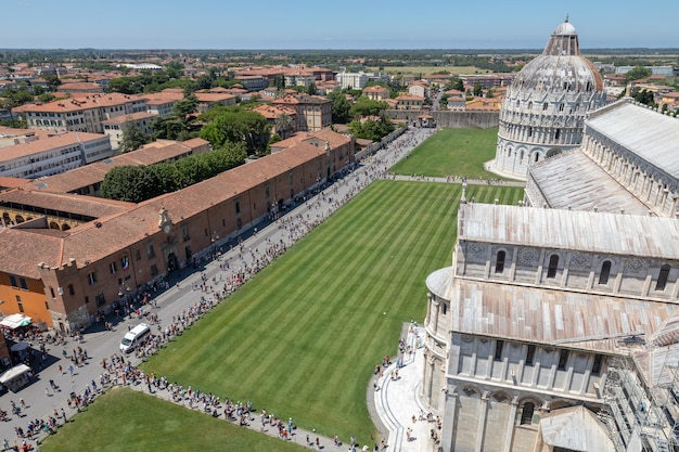 Panoramiczny Widok Na Piazza Del Miracoli Z Baptysterium św. Jana I Katedrą W Pizie Z Wieży W Pizie. Ludzie Chodzą I Odpoczywają Na Placu