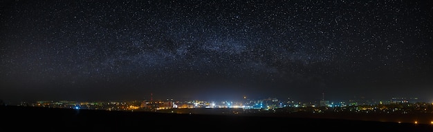 Zdjęcie panoramiczny widok na rozgwieżdżone nocne niebo nad miastem.