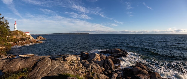 Panoramiczny widok na skaliste wybrzeże oceanu podczas wibrującego, słonecznego zachodu słońca