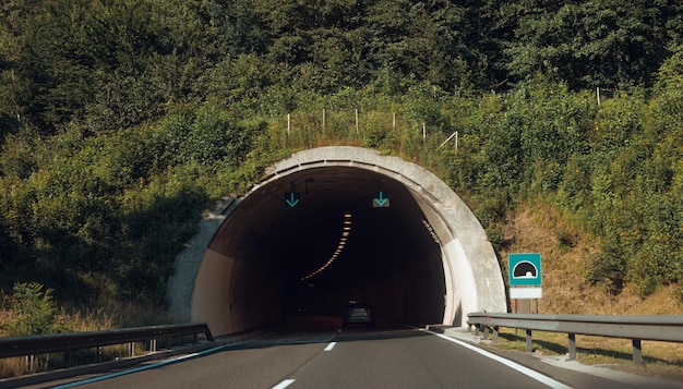 Panoramiczny widok na wejście do tunelu w Europie Krajobraz drogi autostradowej i górskiego lasu