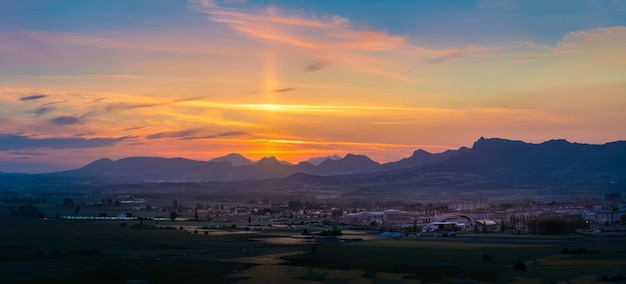 Zdjęcie panoramiczny widok na zachód słońca na góry i wioskę