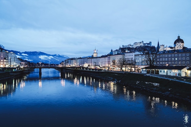 Panoramiczny widok z krajobrazem starego miasta i zamku Hohensalzburg w Salzburgu w Austrii w Europie. Miasto Mozarta w austriackich Alpach w pobliżu rzeki Salzach w zimie. Twierdza i katedra. Wieczorem