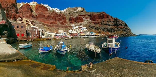 Panoramiczny widok z łodzi rybackich w starym porcie Amoudi miejscowości Oia na wyspie Santorini na Morzu Egejskim, Grecja