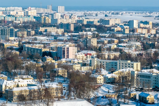 Panoramiczny widok z lotu ptaka na zimowe miasto z sektorem prywatnym i wysokimi obszarami mieszkalnymi ze śniegiem