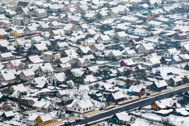 Zdjęcie panoramiczny zimowy widok z lotu ptaka na wioskę ze stodołami i żwirową drogą ze śniegiem