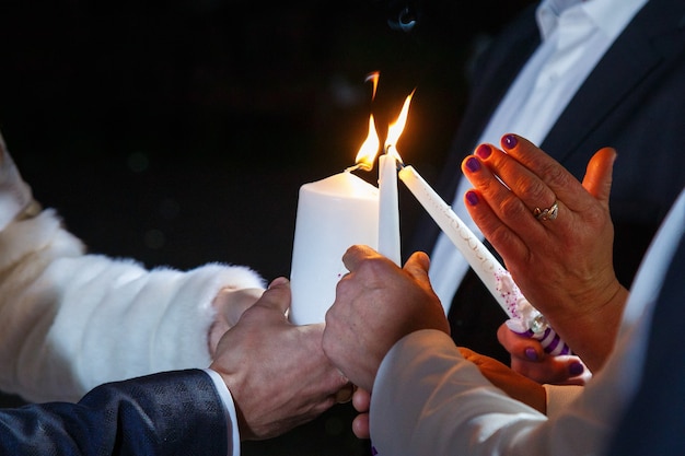 Państwo młodzi wspólnie zapalają świeczkę w dniu ślubu