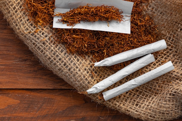 Papier do papierosów i stos tytoniu na drewnianym stole