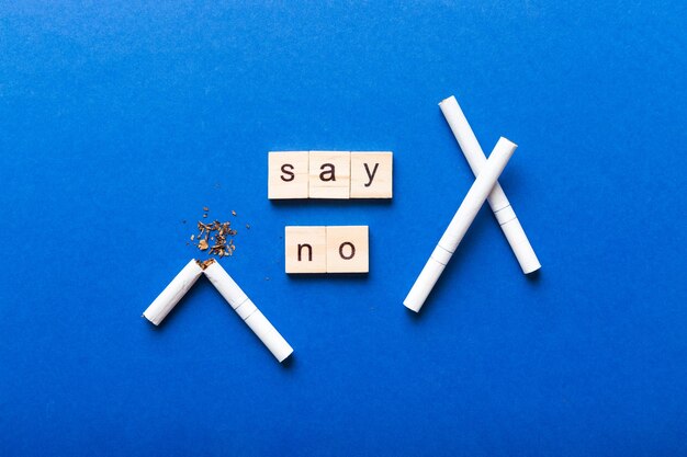 Zdjęcie papieros i drewniane klocki złamany papieros na tle stołu dzień bez tytoniu z zegarem klepsydrowym koncepcja zdrowia czas rzucić palenie