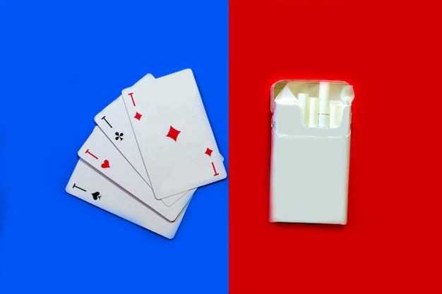 Papierosy i karty papierosy na czerwonym tle i karty na niebieskim tle