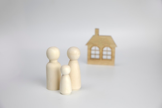 Papierowe figurki rodziny w pobliżu domu na białym tle szczęśliwa rodzina i koncepcja domu rodzice i chi...
