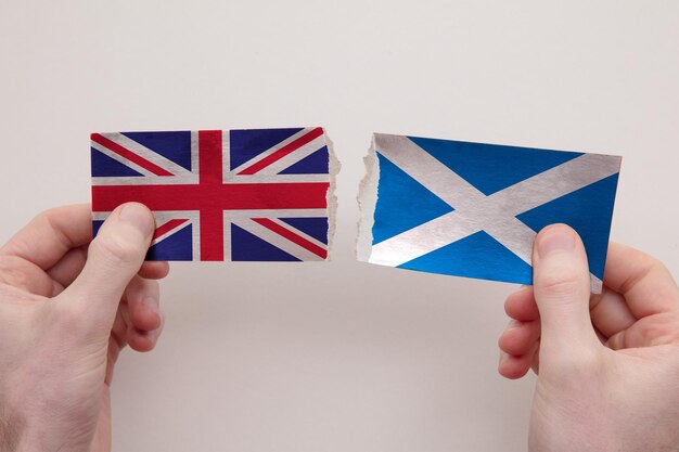 Papierowe flagi Wielkiej Brytanii i Szkocji rozdarte na strzępy koncepcja relacji politycznych