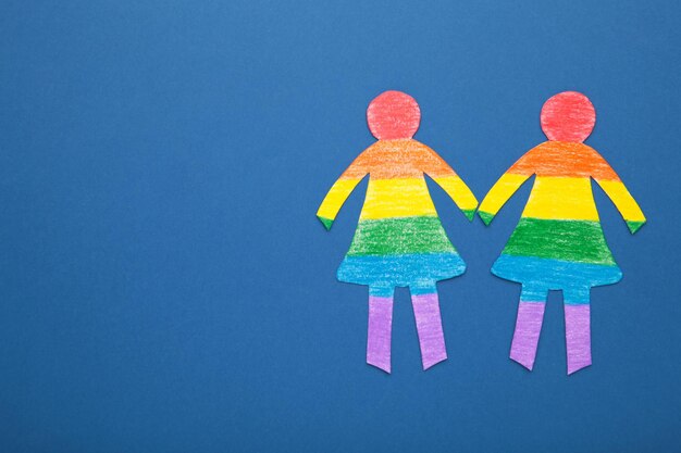 Papierowe kobiety wycięte z papieru i pomalowane w kolorach LGBT Koncepcja LGBT na ciemnoniebieskim Przestrzeń dla tekstu