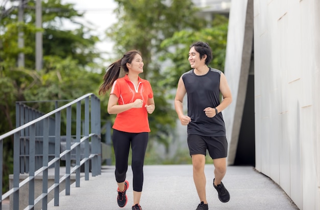 Para Biegająca ćwicząca Na świeżym Powietrzu W Mieście Na Aktywnym Sportowym Zdjęciu Miejskim, Z Budynkami W Tle