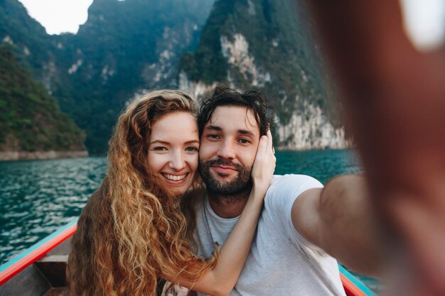 Para bierze selfie na longtail łodzi