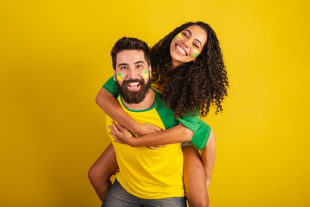 Para brazylijskich kibiców ubrana w barwy narodu czarna kobieta kaukaski mężczyzna całuje miłość