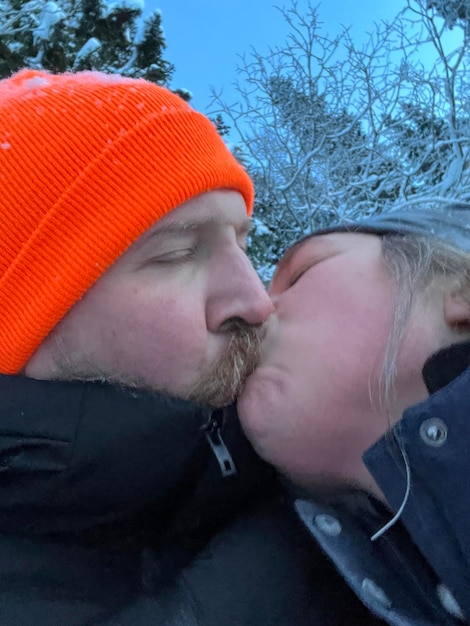 Zdjęcie para całująca się na zewnątrz w zimowy dzień