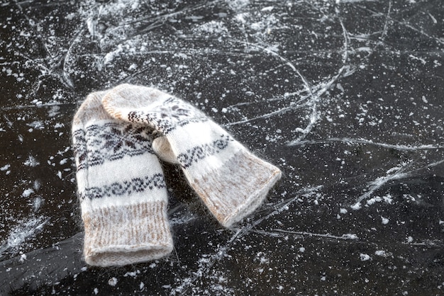 Para ciepłych wełnianych rękawiczek leży na lodzie