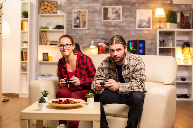 Para Graczy Grających W Gry Wideo Na Telewizorze Z Kontrolerami Bezprzewodowymi W Rękach.