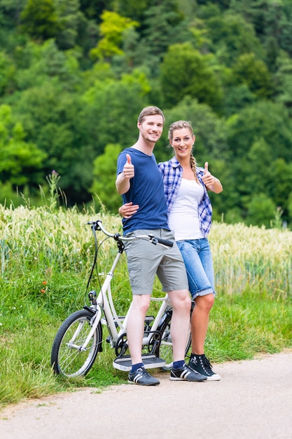 Para jedzie razem na rowerze tandemowym w kraju