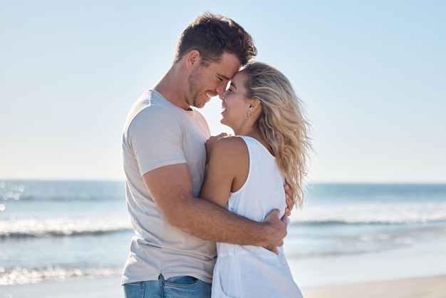 Para kocha się i przytula w związku na plaży na letnie wakacje lub romantyczną więź na świeżym powietrzu Szczęśliwy mężczyzna i kobieta przytulają się z uśmiechem razem w kochającym uścisku na romans nad oceanem