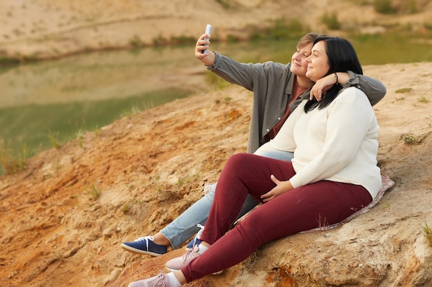 Para Lesbijek Dokonywanie Selfie Portret Na Telefon Komórkowy Siedząc Na Wzgórzu Na łonie Natury