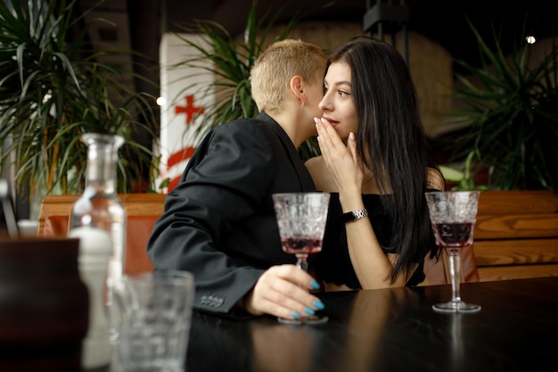 Zdjęcie para lesbijek na randce w restauracji pije wino