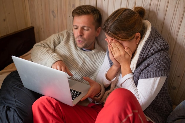 Para leżąca na łóżku w sypialni za pomocą laptopa