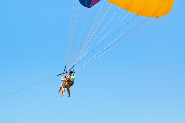 Para ludzi parasailing na spadochronie w błękitne niebo