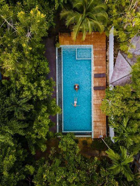 para mężczyzn i kobiet w basenie w dżungli Krabi w Tajlandii widok z powietrza z dronem nad basenem w dżingli Tajlandii