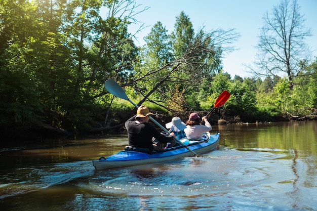 Para mężczyzna i kobieta w rodzinnym spływie kajakowym wiosłowanie łódką po rzece wycieczka wodna letnia przygoda Turystyka ekologiczna i ekstremalna aktywny i zdrowy styl życia
