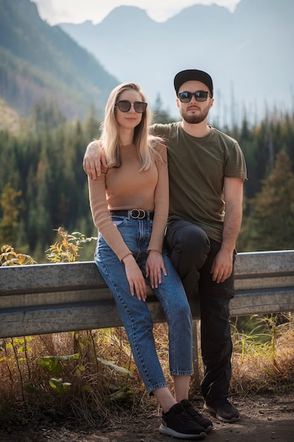 Para młodych turystów, mężczyzna i kobieta, na szlaku w górach w słoneczny dzień