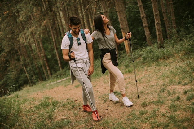 Para młodych wędrowców z plecakami spaceruje po lesie