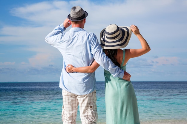 Para na wakacjach spaceru na tropikalnej plaży Malediwy. Mężczyzna i kobieta romantyczny spacer po plaży.