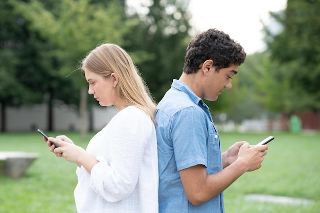 Para Nastolatków Stojąca Plecami Do Siebie I Używająca Telefonów