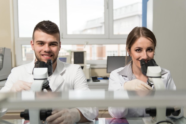 Para naukowców patrząca w mikroskop