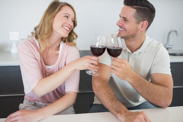 Zdjęcie para opiekania kieliszki do wina czerwonego przy stole