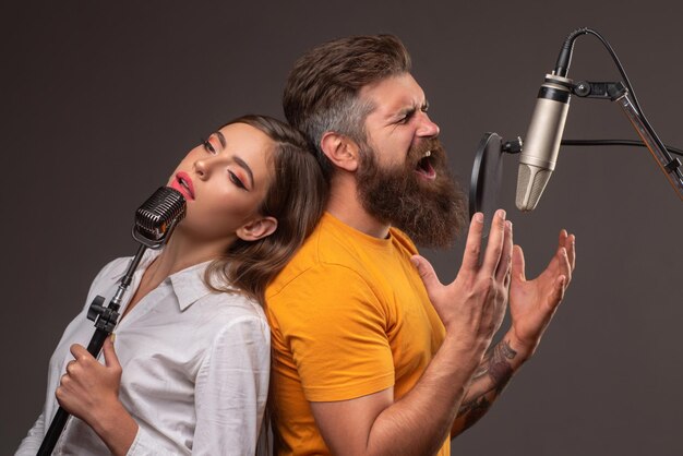 Para piosenkarzy śpiewających rock producent dźwięku nagrywa piosenkę w studiu muzycznym podekscytowany duet karaoke