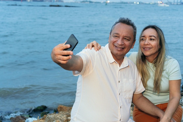 Para po pięćdziesiątce robi selfie telefonem komórkowym