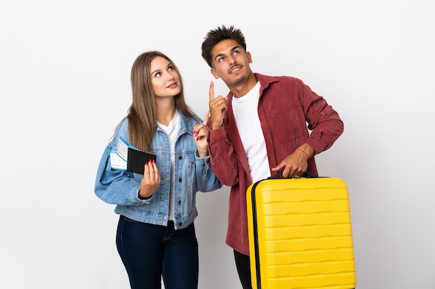Para podróżujących trzymając walizkę na niebiesko, wskazując palcem wskazującym świetny pomysł