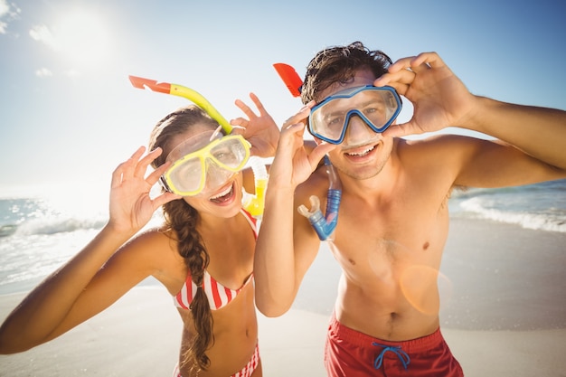 Para pozuje z pikowanie maską na plaży