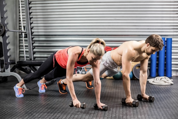 Para robi push up z hantlami na siłowni crossfit