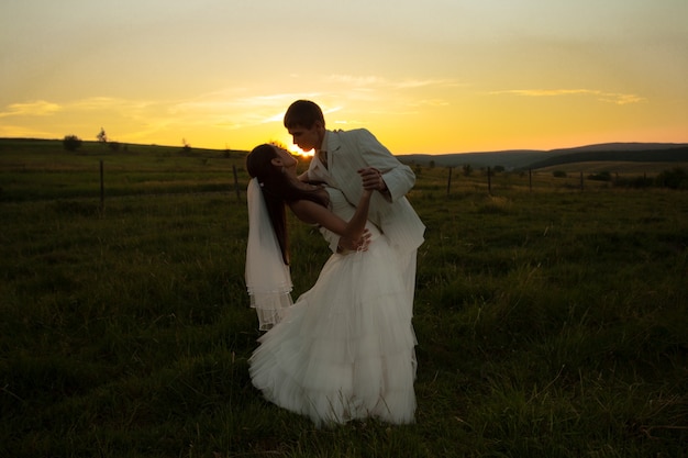 Para ślubna tańczy o zachodzie słońca